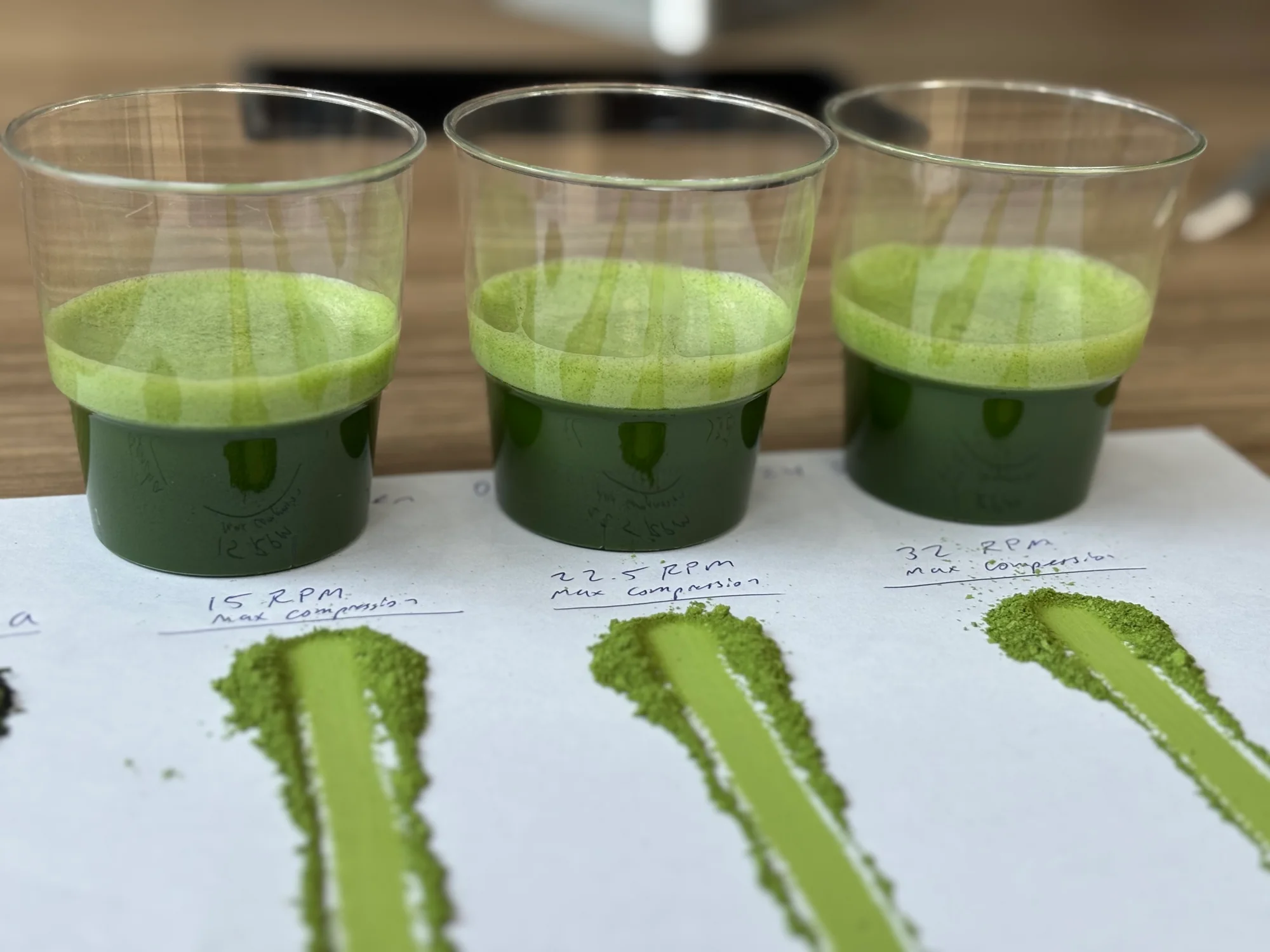 Three bowls of matcha milled at different speeds, each beside a smear of its powder