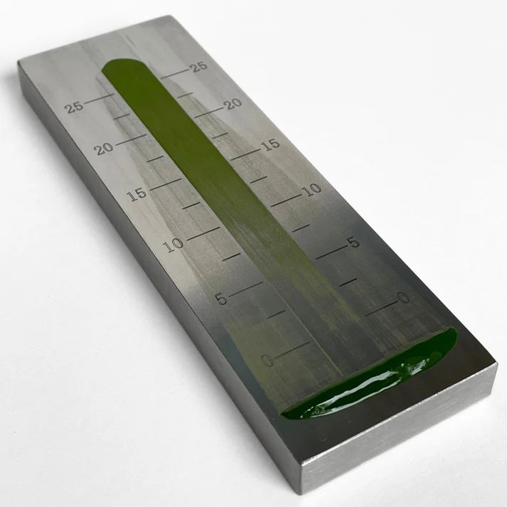 The grindometer plate with a matcha streak drawn down its channel